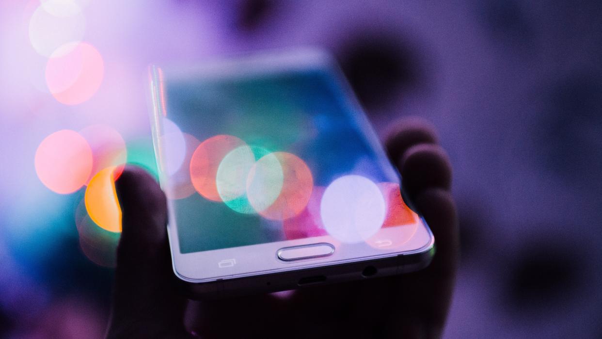 Artistic photo of a hand holding a mobile phone