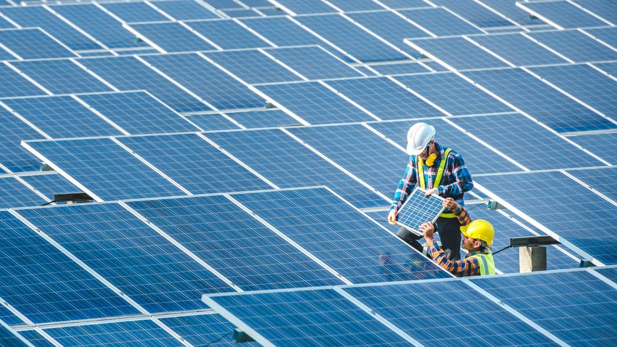 Image: Two Asian engineering teams are installing solar panels.