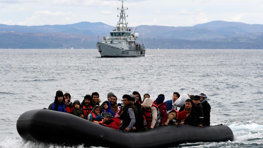 Bild: Flüchlinge auf einem Schlauchboot im Mittelmeer, dahinter ein Frontex-Schiff