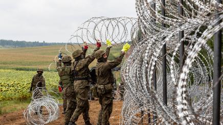 Polish Army Soldiers build a fence with concertina wire at the Belarusian border in order to stop immigrants from entering the country in Krynki, Poland on 27 August, 2021.