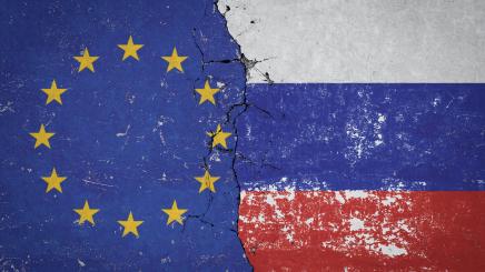 Flagge Russlands und Flagge der Europäischen Union an einer alten beschädigten Mauer
